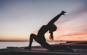 a woman doing yoga on a beach